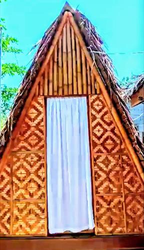 a building with a window with a straw roof at SHUKRAN Apartelle in Siquijor
