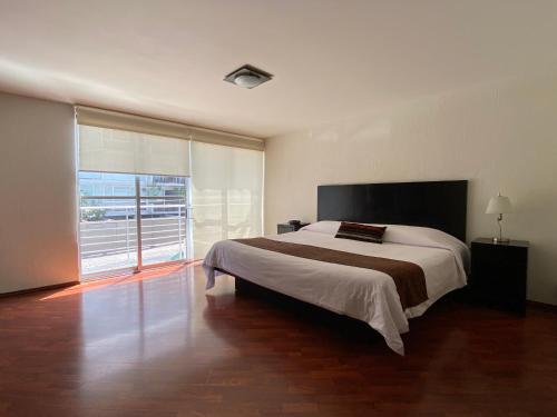 a bedroom with a large bed and a large window at Grupo Kings Suites - Monte Chimborazo 567 in Mexico City
