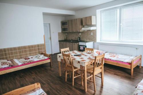 a room with a table and chairs and a kitchen at Klub U Námořníka in Dvůr Králové nad Labem