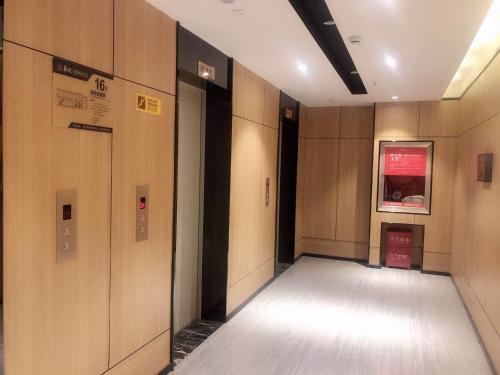 a hallway with wooden walls and doors in a building at IU Hotel Guiyang Olympic Sports Center China Resources Vientiane in Guiyang