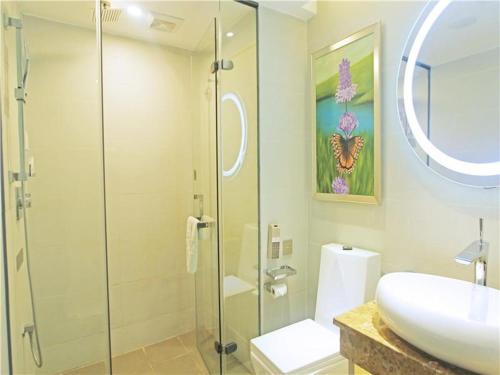 a bathroom with a sink and a glass shower at Lavande Hotel Guiyang Flower Orchard Fortune Plaza in Guiyang