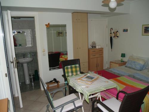 a room with a bed and a table and chairs at Villa Verde Apart-Hotel in Nea Makri