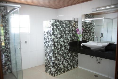a bathroom with a sink and a shower at Pousada Villa da Serra in Brumadinho