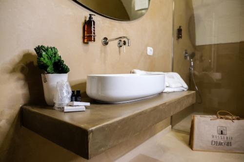 a bathroom with a white sink on a counter at Masseria D'Erchia in Monopoli