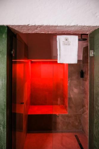 a glass shower with red lighting in a bathroom at Masseria D'Erchia in Monopoli