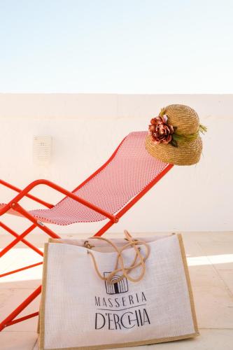 a red chair with a sign and a shopping bag at Masseria D'Erchia in Monopoli