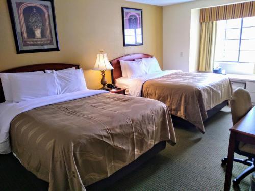 a hotel room with two beds and a window at Quality Inn & Suites in Prestonsburg