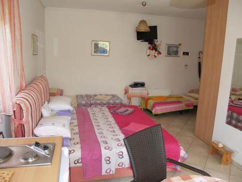a room with a bed with a table and a sink at Villa Verde Apart-Hotel in Nea Makri