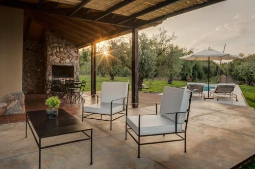 a patio with chairs and a table and an umbrella at Posada Verde Oliva in Maipú