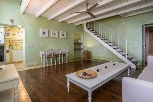 a living room with a white table and a staircase at Villa Cassia di Baccano in San Giustino Valdarno