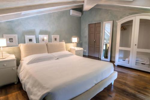 a bedroom with a large white bed and two lamps at Villa Cassia di Baccano in San Giustino Valdarno
