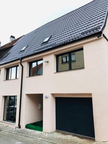 a white house with a black garage door at Carla Maria S Hause in Gammertingen