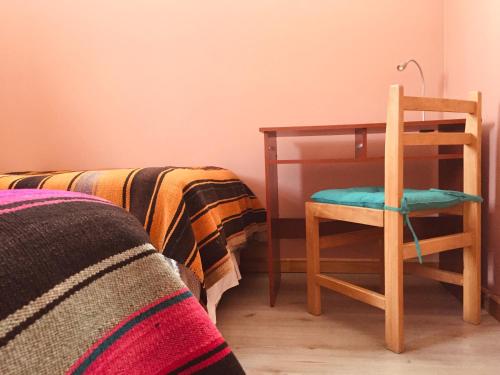a bedroom with a desk and a chair next to a bed at Sol del Desierto in Chíuchíu