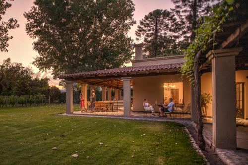 a group of people sitting on the porch of a house at Posada Verde Oliva in Maipú