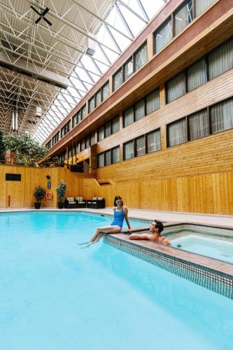 a man and a woman sitting in a swimming pool at Forest Park Hotel in Jasper