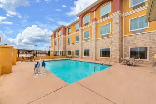 una imagen de una piscina frente a un edificio en Residency Suites, en Cotulla