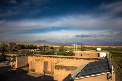 a view of a desert with a windmill and buildings at Sol del Desierto in Chíuchíu