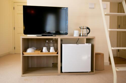 a tv sitting on top of a shelf with a refrigerator at Ryosha Tsukiakari in Yamanakako