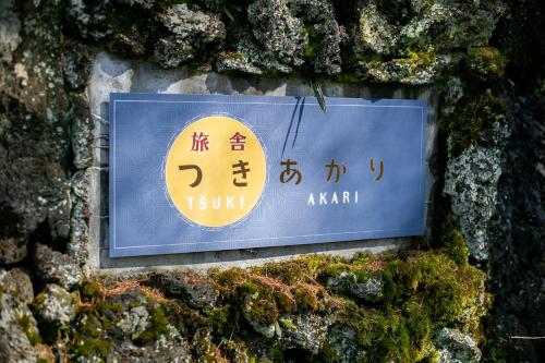 a sign on the side of a stone wall at Ryosha Tsukiakari in Yamanakako