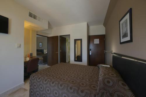 ベラクルスにあるHotel Mar y Tierraのベッドと机があるホテルの部屋