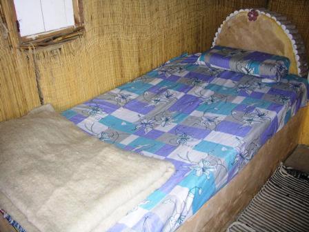 Cama pequeña en habitación con ventana en Badry Sahara Camp, en Bawati