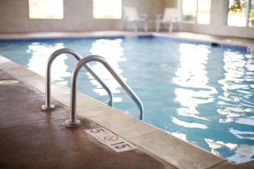 a swimming pool with a stairway leading into the water at Hyatt House Indianapolis Fishers in Fishers