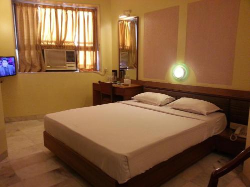 Un pat sau paturi într-o cameră la Hotel Ashray International, Sion