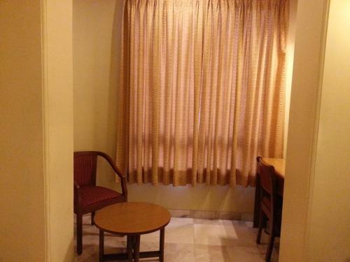 a room with a table and a chair and a window at Hotel Ashray International, Sion - Near BKC in Mumbai