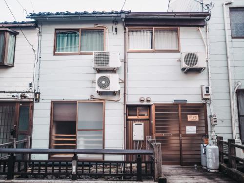 a white building with windows and a door at Nishichaya TABI-NE in Kanazawa