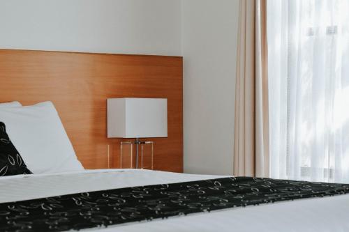 a bedroom with a bed with a wooden headboard at The Charles in Wagga Wagga