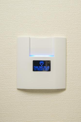 a white lightswitch on a wall with a label at Hotel Yassa in Mihara