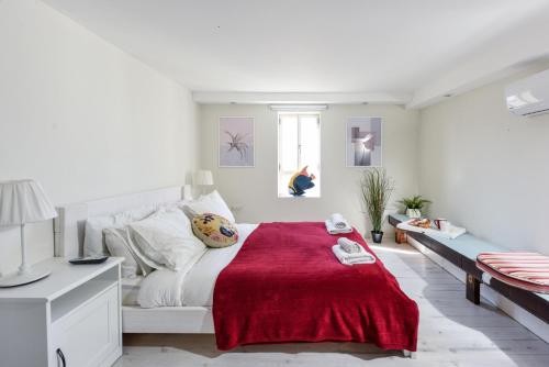 a white bedroom with a red blanket on a bed at TLV Loft Paradise with Balcony, Roof Top & Mamad by Sea N' Rent in Tel Aviv