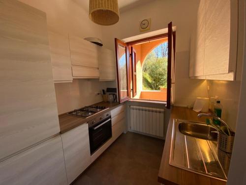 uma pequena cozinha com um lavatório e uma janela em Argentella House em Palombara Sabina