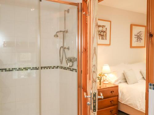 ein Bad mit Dusche und ein Bett in der Unterkunft Court Prior Cottage in Totnes