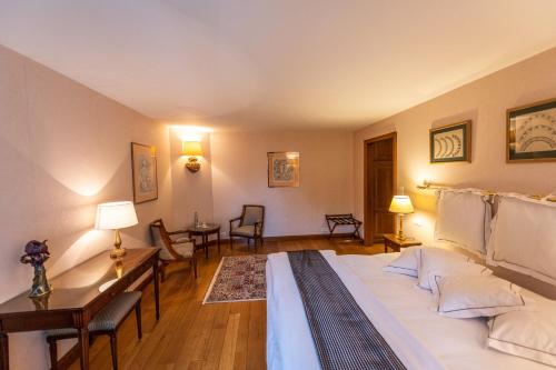 a bedroom with a bed and a living room at Auberge Saint Walfrid Hôtel Restaurant & Spa in Sarreguemines