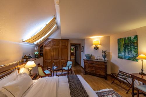 a bedroom with a bed and a table and chairs at Auberge Saint Walfrid Hôtel Restaurant & Spa in Sarreguemines