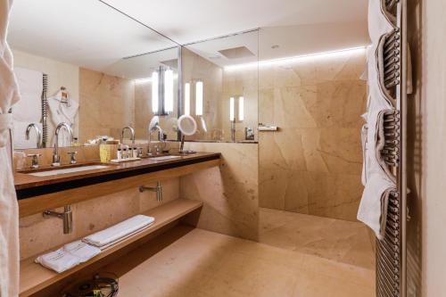 a bathroom with two sinks and a shower at Auberge Saint Walfrid Hôtel Restaurant & Spa in Sarreguemines