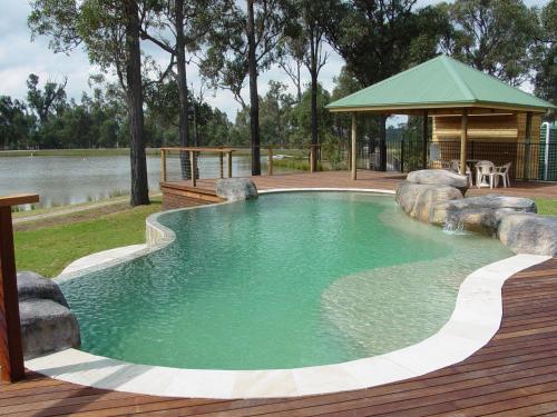 a large swimming pool with a gazebo in a yard at RidgeView in Pokolbin