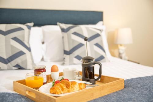a breakfast tray with croissants and eggs on a bed at Queen Anne's Home in Great Yarmouth