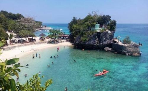 a group of people in the water at a beach at First Baby Bytes Guest House in Siquijor