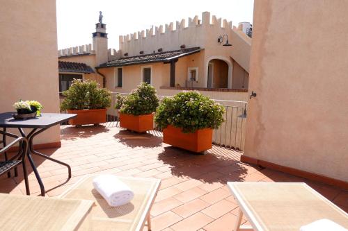 un patio avec des tables et des plantes en pot et un bâtiment dans l'établissement Agriturismo del Pigato - Bio Vio, à Albenga