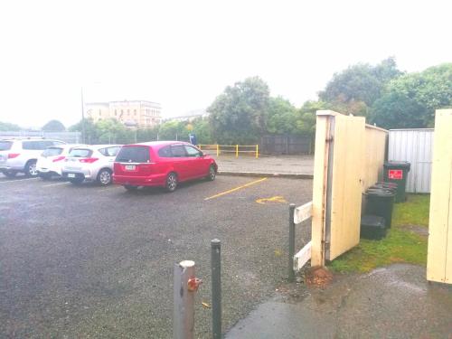 a red car parked in a parking lot at Empire Hotel Backpackers in Oamaru