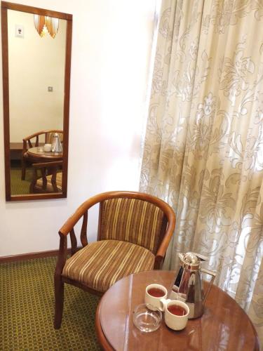 a room with a table and a chair and a mirror at Oriental Palace Hotel in Manama