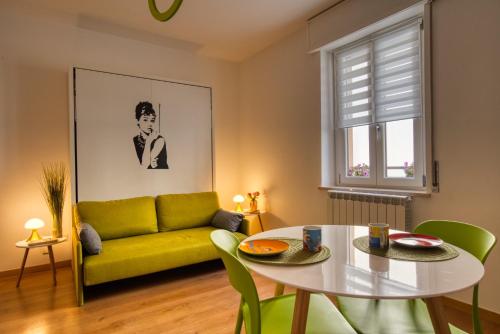 uma sala de estar com um sofá amarelo e uma mesa em CaseOspitali - CASA DIVA monolocale in centro storico em Cernusco sul Naviglio