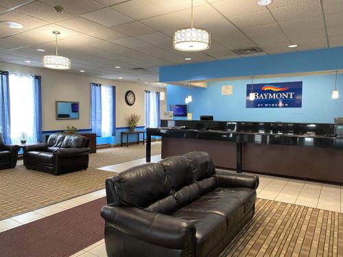 a waiting room with a leather couch in a lobby at Baymont by Wyndham Queensbury/Lake George in Queensbury