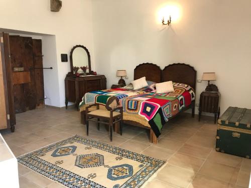 a bedroom with a bed and a chair and a mirror at Abruzzo Forte e Gentile in Castel di Ieri