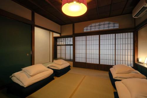 a room with two beds in a room with windows at SAKON UKON in Kanazawa