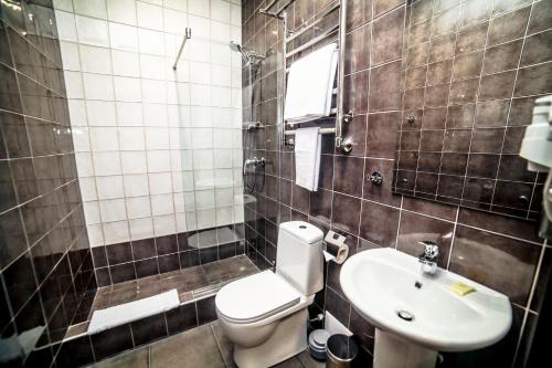 a bathroom with a toilet and a sink at Business Hotel in Magnitogorsk