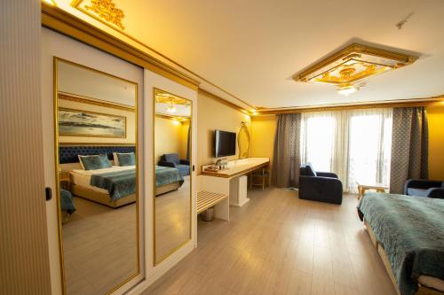 a hotel room with two beds and a desk at Empire Suite Hotel in Istanbul