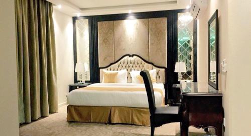 a bedroom with a large bed and a desk and a bed sidx sidx sidx sidx at Al Sharq Hotel in Hafr Al Baten